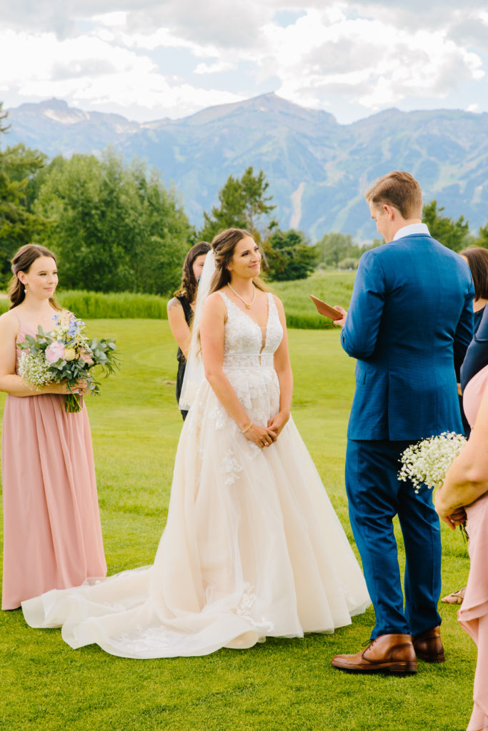 Jackson Hole wedding photographer captures groom reading vows to bride at classy jackson hole wedding venues 