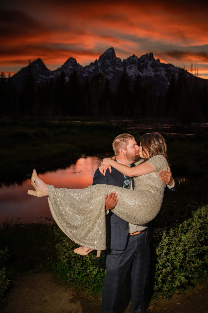 Jackson Hole elopement photographer captures groom lifting bride and kissing her