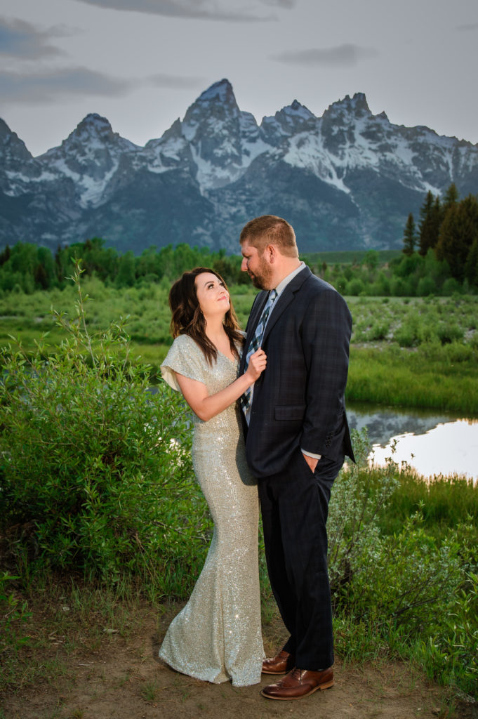 Jackson Hole elopement photographer captures bride holding man's suit jacket looking up at him