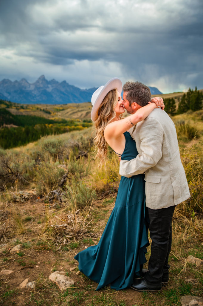 Jackson Hole elopement photographer captures bride wearing deep blue dress kissing husband after last minute Jackson hole elopement