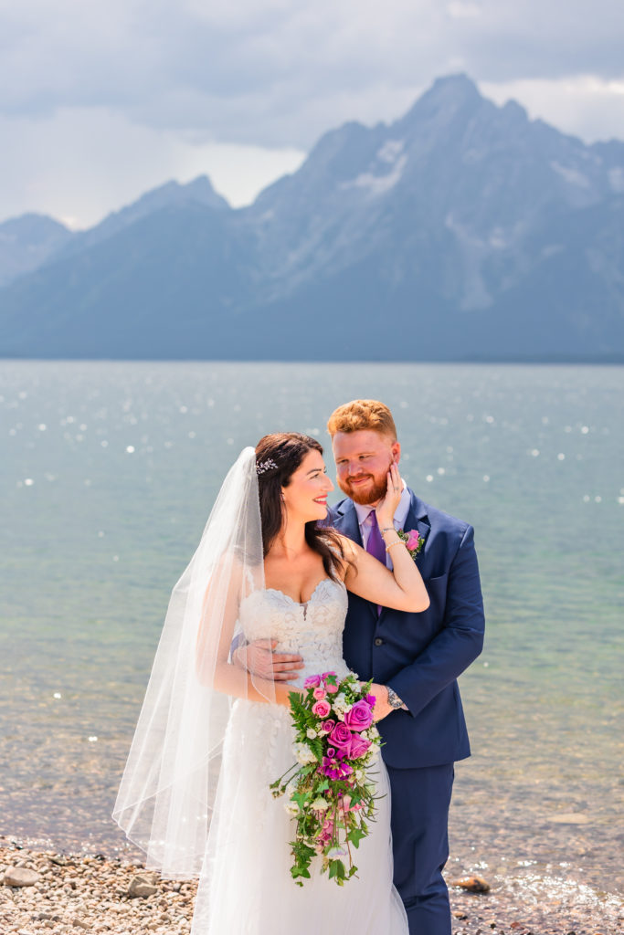 Jackson Hole wedding photographer captures couple embracing while wearing wedding attire during grand teton elopement