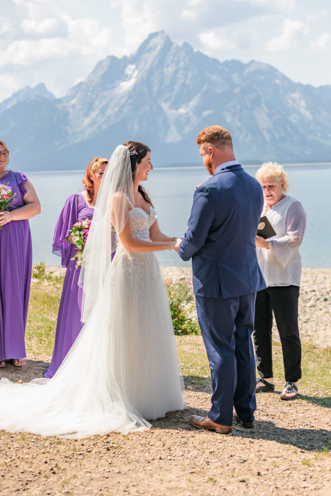 Jackson Hole wedding photographer captures bride and groom holding hands during colter bay elopement ceremony