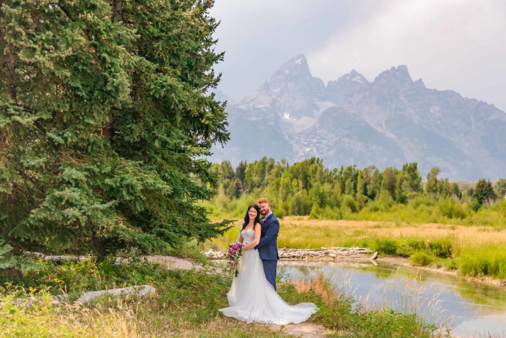 Jackson Hole wedding photographer captures bride and groom holding hands and embracing during bridal portraits