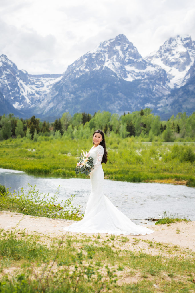 Jackson Hole wedding photographer captures bride looking over shoulder holding bouquet