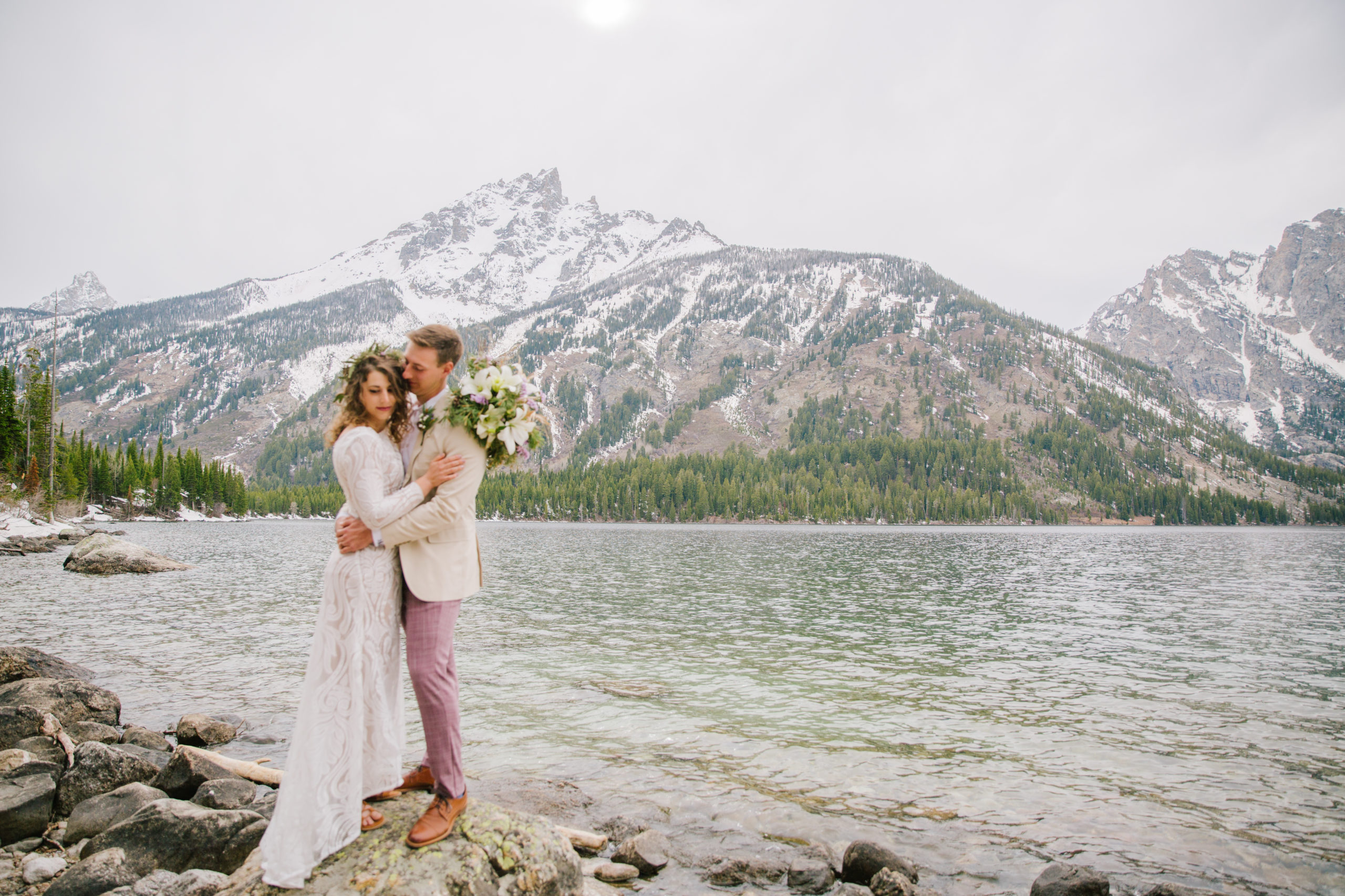 Jackson Hole elopement photographer captures couple embracing at Jenny Lake during bridal portraits