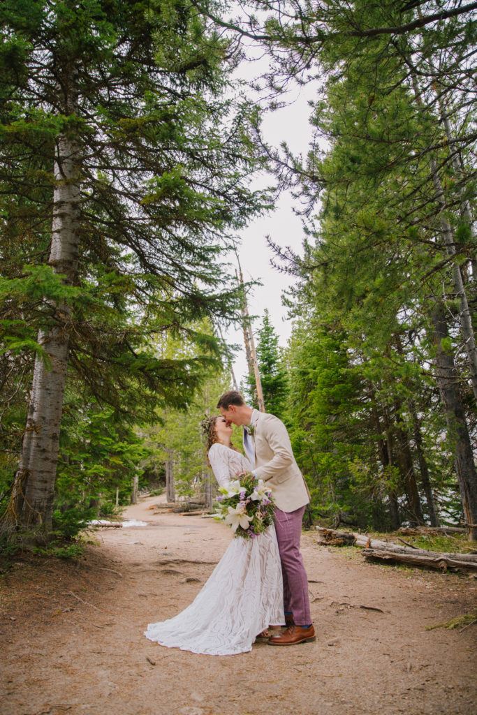 Jackson Hole elopement photographer captures couple kissing in forest during elopement portraits