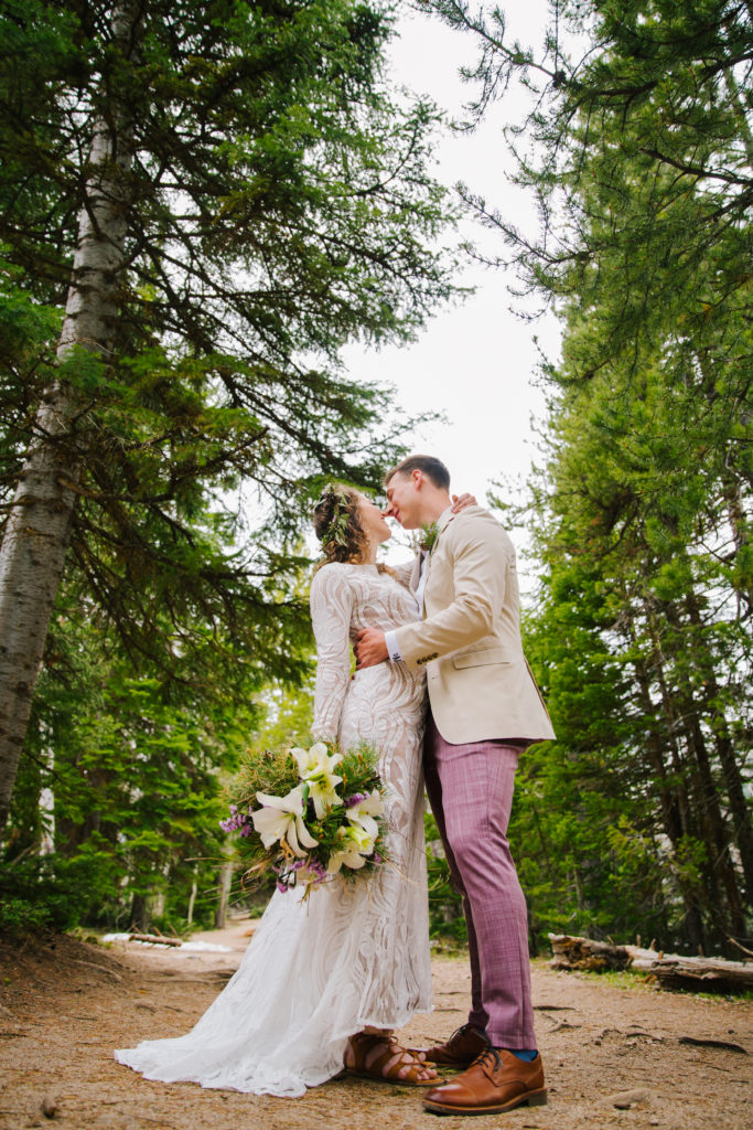 Jackson Hole elopement photographer captures couple kissing in forest in Grand Teton wedding portraits