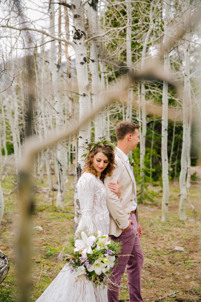 Jackson Hole wedding photographer captures couple in forest wearing wedding attire