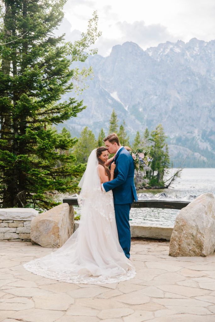 Jackson Hole photographers capture newly married couple embracing during bridal portraits in Grand Teton