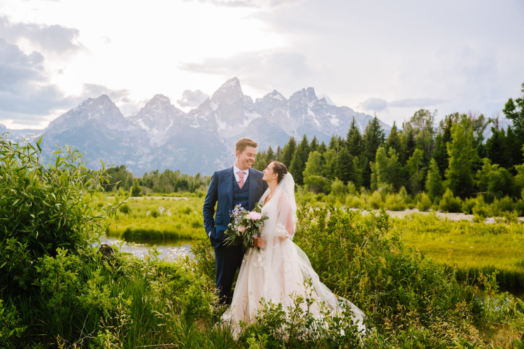 Jackson Hole wedding photographers capture bride and groom looking at one another during bridal portraits