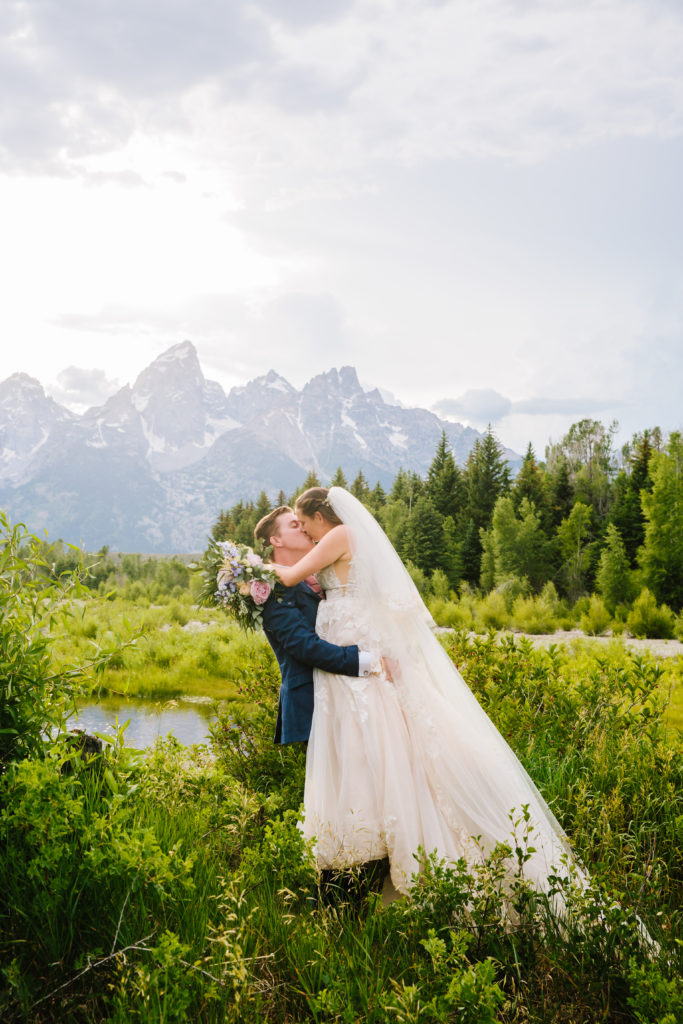 Jackson Hole photographers capture bride and groom kissing in Grand Teton wedding location