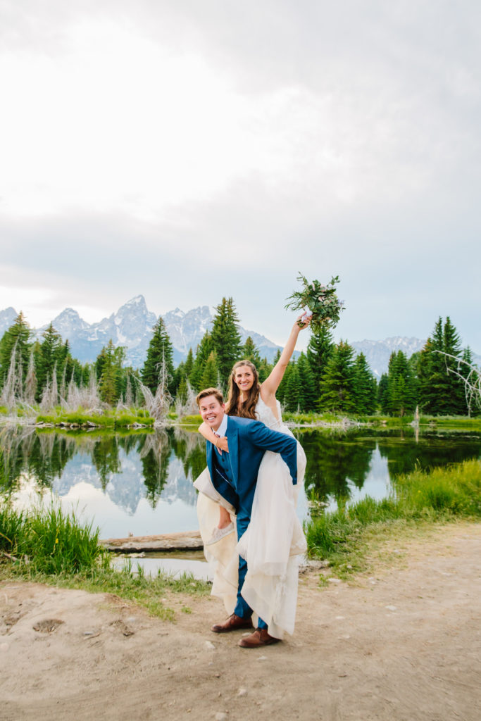 Jackson Hole wedding photographer captures bride on groom's back during portraits