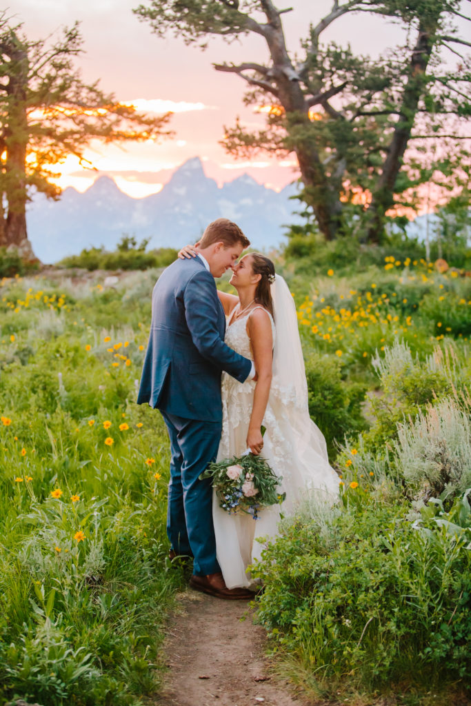 Jackson Hole wedding photographers capture newly married couple embracing during sunset