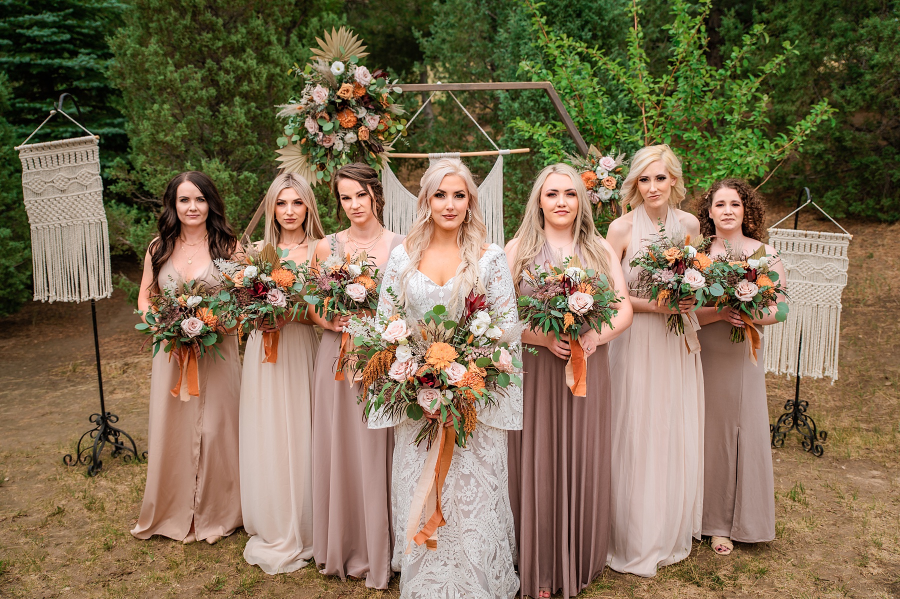 Jackson Hole wedding photographer captures bride standing with bridesmaids wearing varying shades of pink bridesmaid dresses