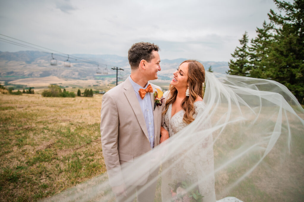Jackson Hole elopement photographer captures couple embracing during bridal portraits with veil across frame