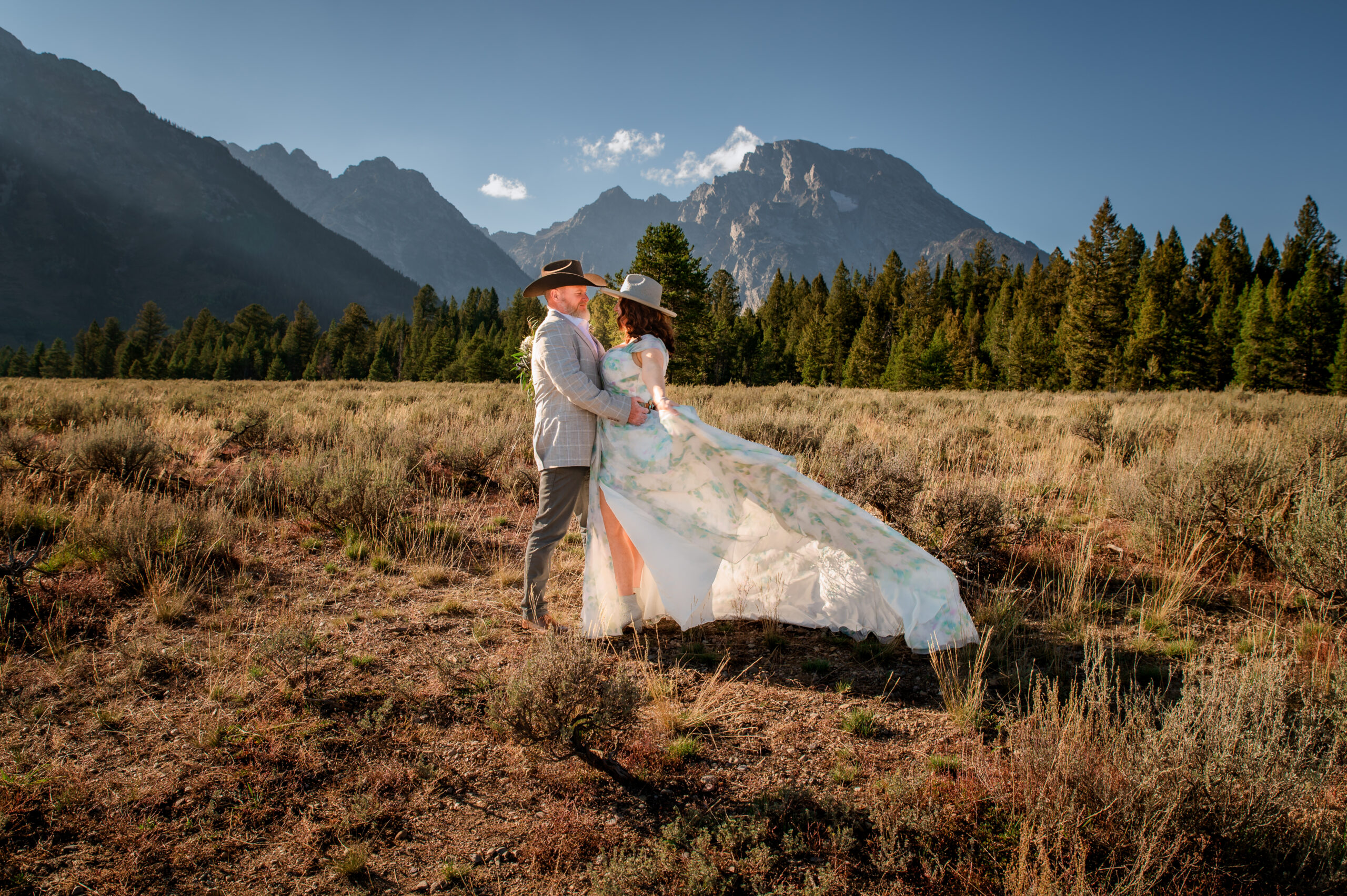 Jackson Hole photographers capture bride and groom standing together in grand teton national park during portraits