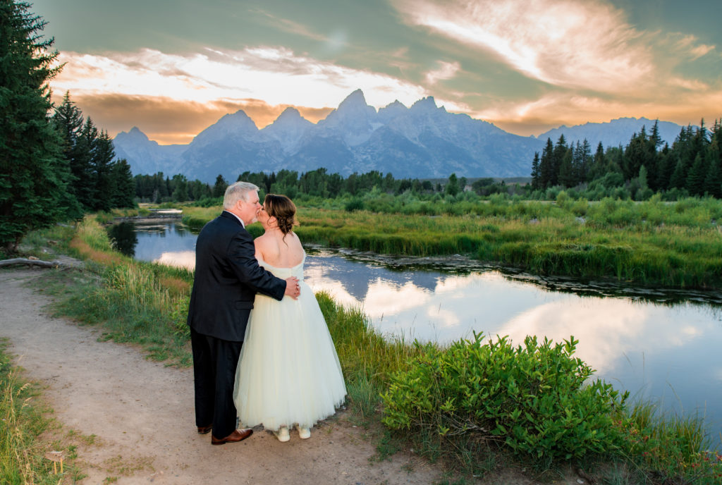 Jackson Hole photographers capture bride and groom embracing during sustainable grand teton wedding