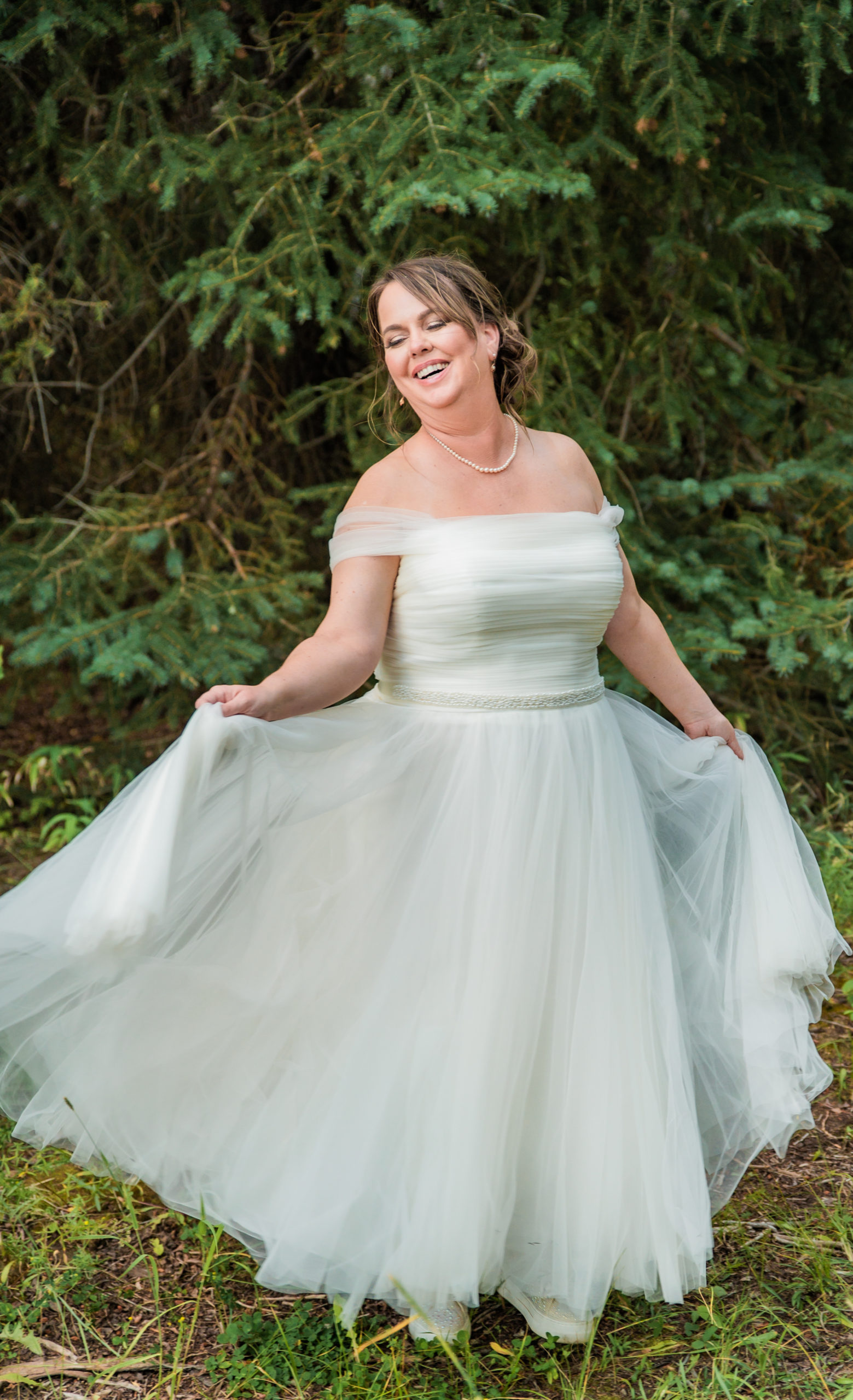 Jackson Hole photographer captures bride holding dress in Schwabacher's Landing Summer Elopement
