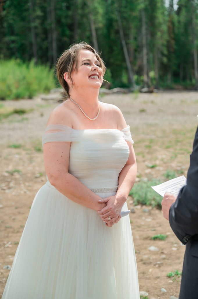 Jackson Hole elopement photographer captures bride laughing during vows