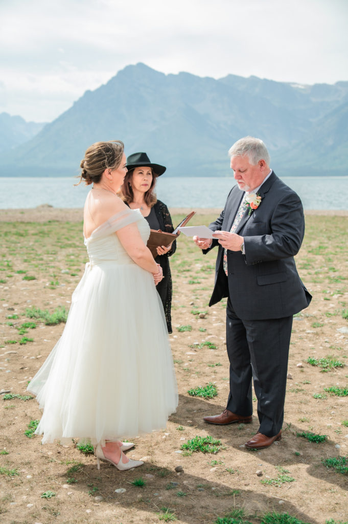 Jackson Hole elopement photographer captures groom reading vows during Grand Teton wedding