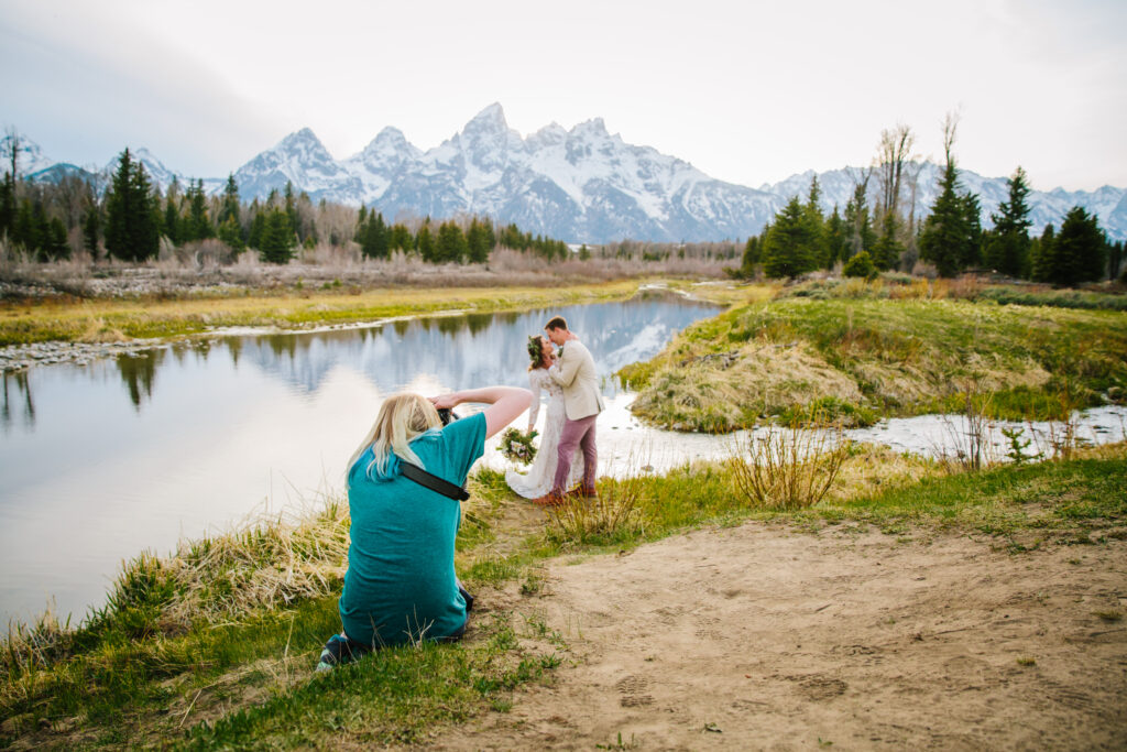 Jackson Hole photographer captures Sadie of Love and Story studio taking pictures of bride and groom during grand teton wedding