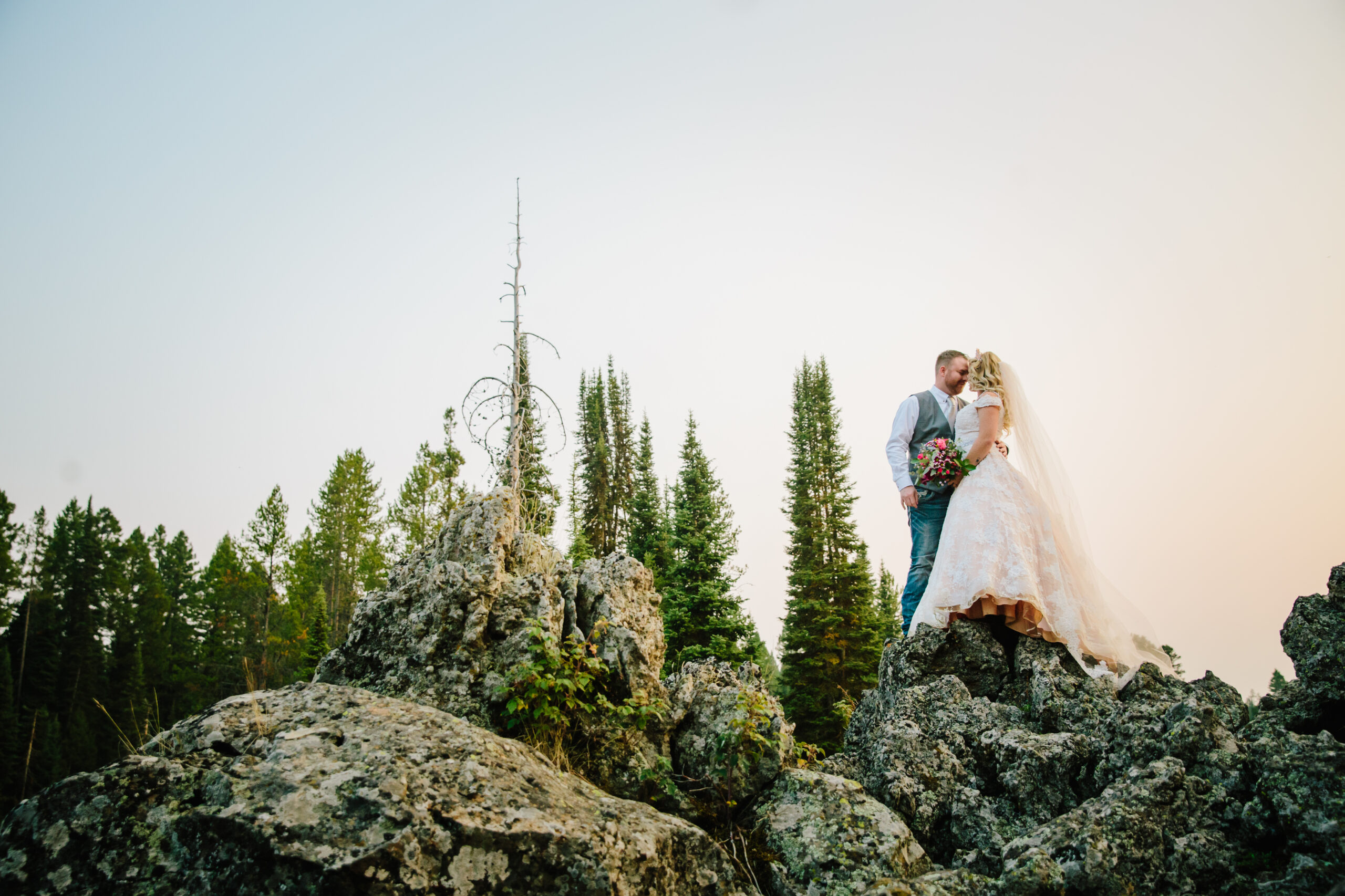 Jackson Hole photographer captures bride and groom on rock during outdoor portraits