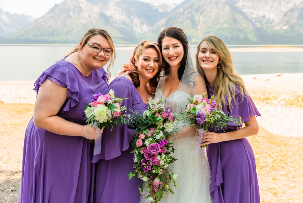 Jackson Hole elopement photographer captures bride standing with wedding party after they buy bridesmaid dresses online
