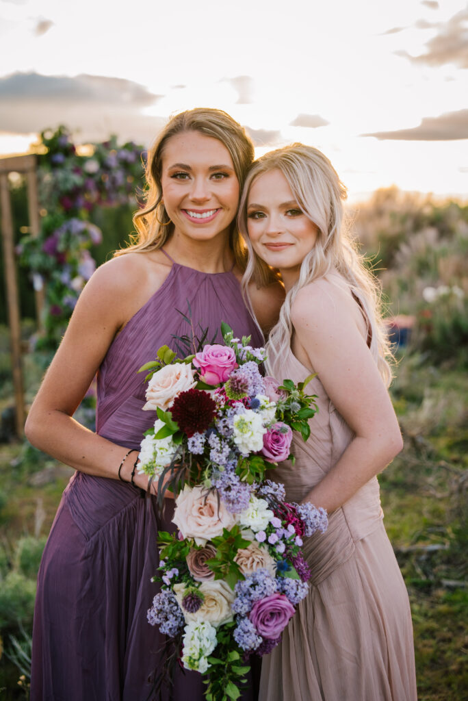 Bridesmaids in shades of purple pose with their flowers in Jackson Hole, Wyoming.