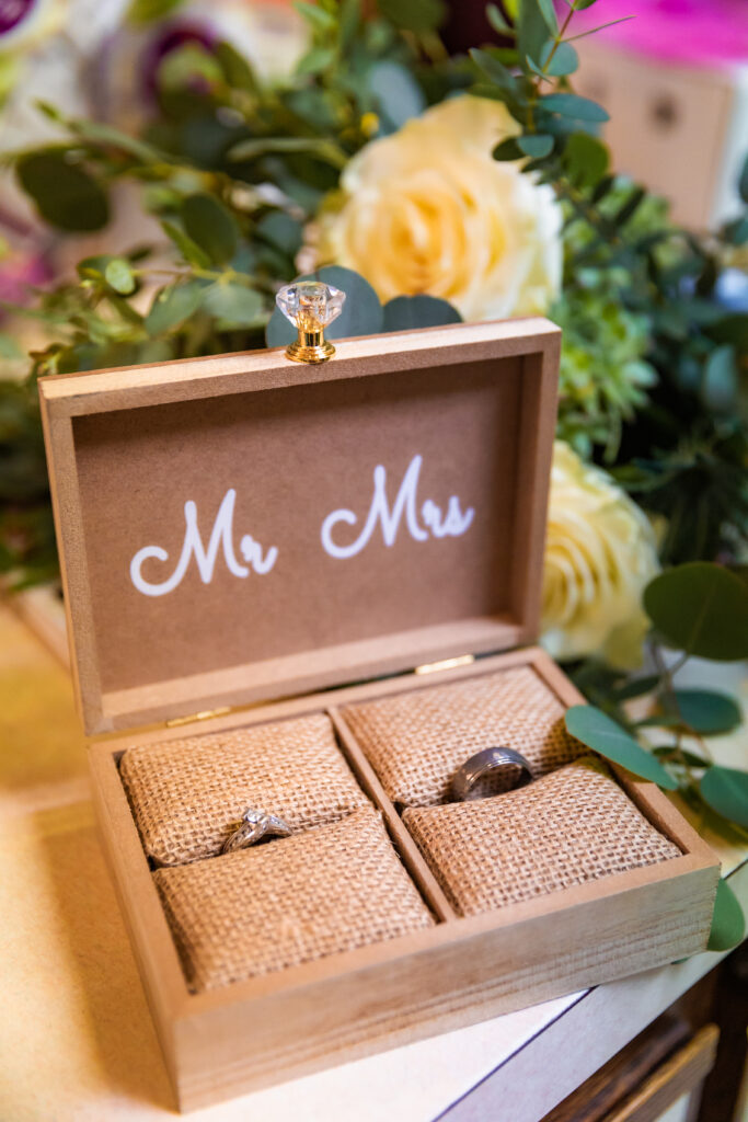 Ring box for grand teton elopement sits on counter with flowers behind it right before grand teton elopement.